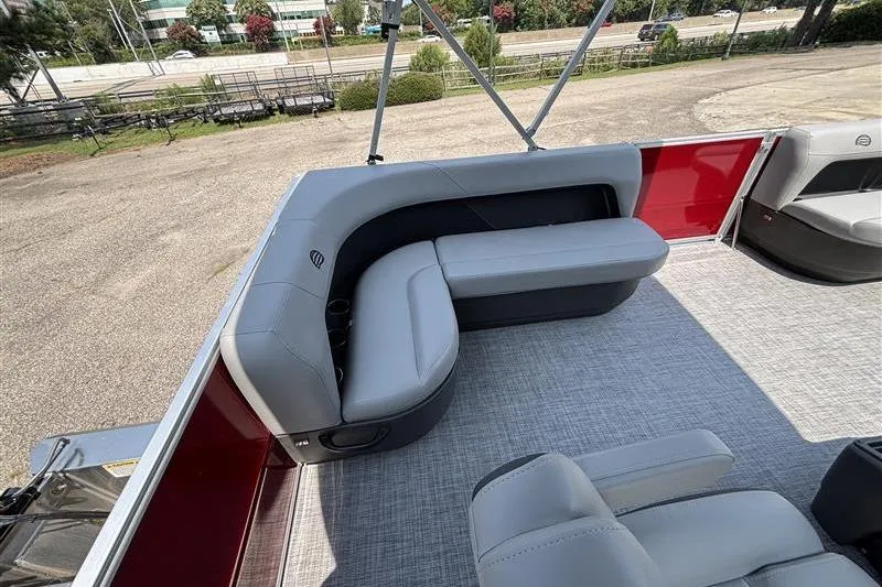 Slide: The Image of 2026 Sun Tracker Party Barge 16 DLX interior with gray seating and red accents. - 16