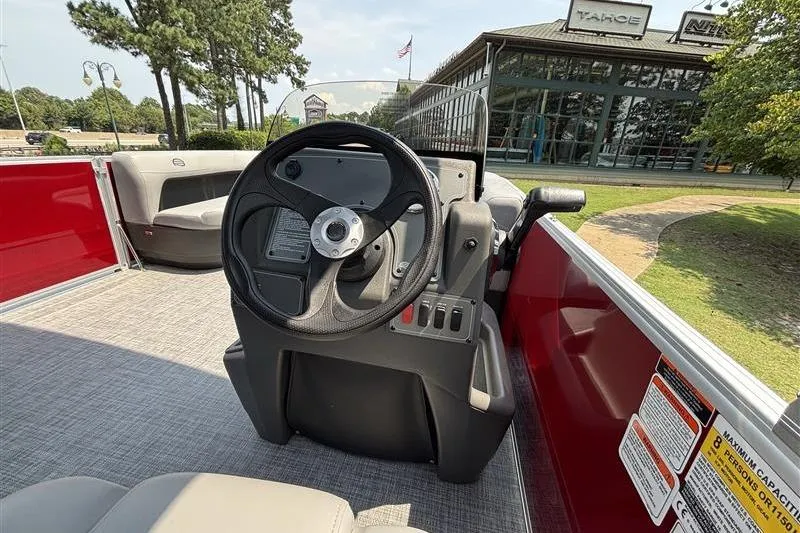 Slide: The Image of 2026 Sun Tracker Party Barge 16 DLX interior with steering wheel and seating area. - 14