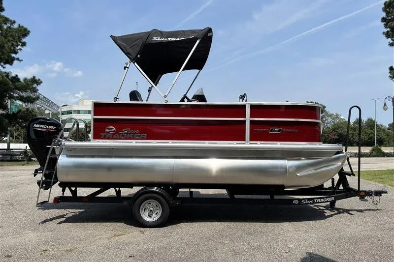 Slide: The Image of 2026 Sun Tracker Party Barge 16 DLX pontoon boat on trailer, parked outdoors. - 4