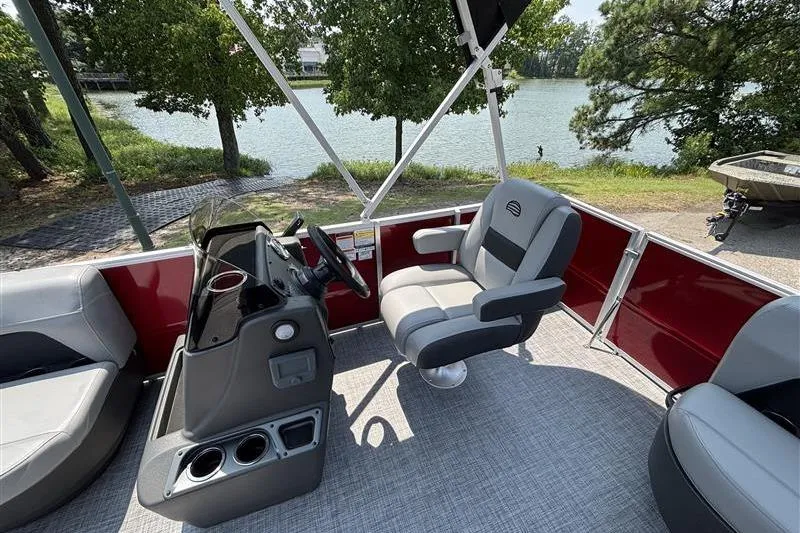 Slide: The Image of 2026 Sun Tracker Party Barge 16 DLX interior with captain's chair and steering console. - 11