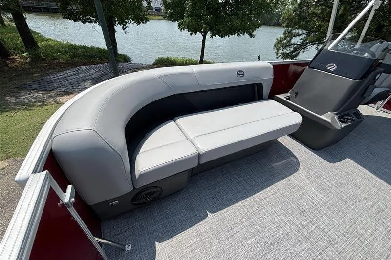 Slide: The Image of 2026 Sun Tracker Party Barge 16 DLX interior with gray seating, near a serene lake. - 7