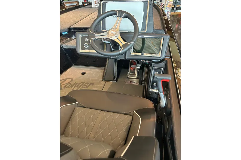 Slide: The Image of 2026 Ranger Z521R Cup-Equipped boat cockpit with steering wheel and control panel. - 2