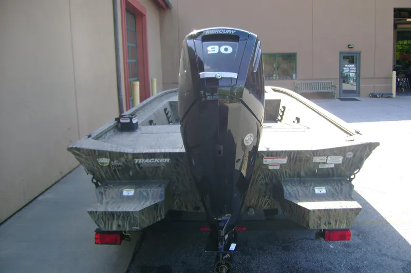 Slide: The Image of 2026 Tracker Grizzly 1860 CC boat with Mercury 90 engine, parked outdoors. - 4
