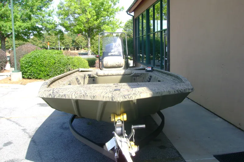 Slide: The Image of 2026 Tracker Grizzly 1860 CC boat on trailer, parked outdoors near building. - 3
