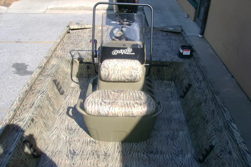 Slide: The Image of 2026 Tracker Grizzly 1860 CC boat with camouflage interior and central console. - 6