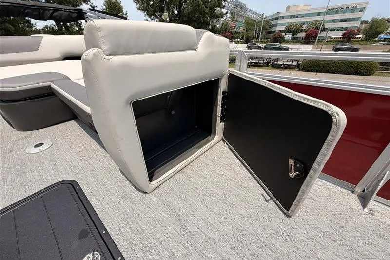 Slide: The Image of 2026 Sun Tracker Fishin' Barge 22 XP3 storage compartment with open door on deck. - 18