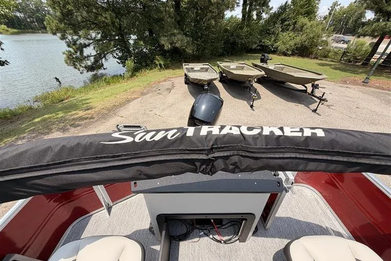 Slide: The Image of 2026 Sun Tracker Fishin' Barge 22 XP3 at lakeside with boats in background. - 23