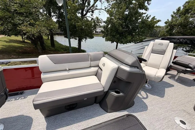 Slide: The Image of 2026 Sun Tracker Fishin' Barge 22 XP3 interior with comfortable seating by the water. - 11