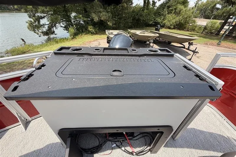 Slide: The Image of 2026 Sun Tracker Fishin' Barge 22 XP3 boat console with storage and cup holders. - 21