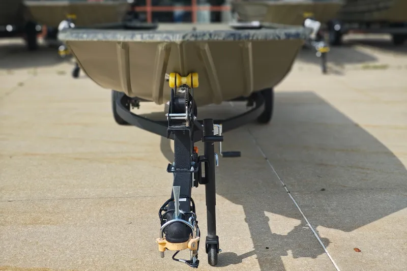 Slide: The Image of 2026 Tracker Grizzly 1648 Utility boat on trailer, front view, parked on concrete. - 3