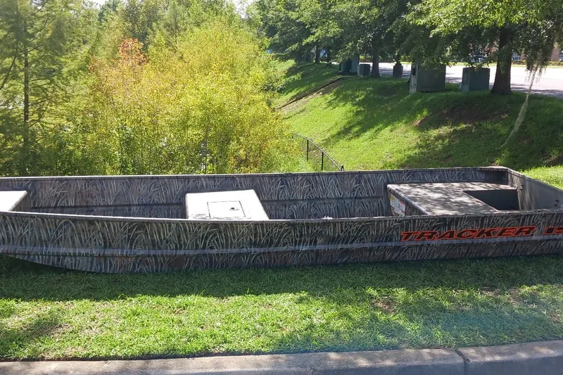 The Image of 2026 Tracker Grizzly 15 Jon boat with camouflage design on grassy area. - 0