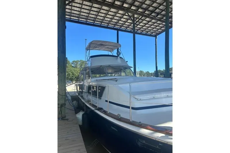 The Image of 1978 Chris-Craft 45 Commander yacht docked under a covered marina. - 1