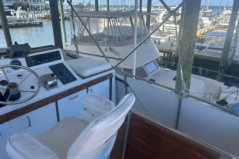 Slide: The Image of 1978 Chris-Craft 45 Commander yacht helm with marina view in the background. - 10