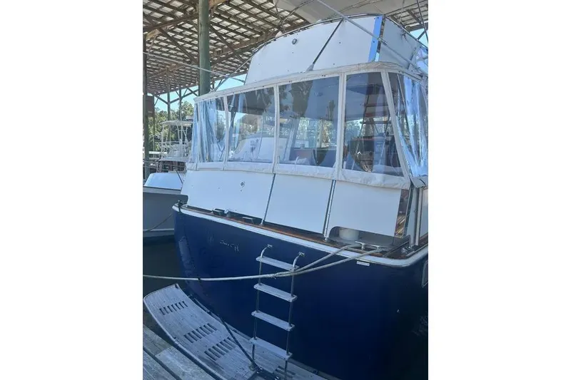 Slide: The Image of 1978 Chris-Craft 45 Commander yacht docked under a covered marina. - 16