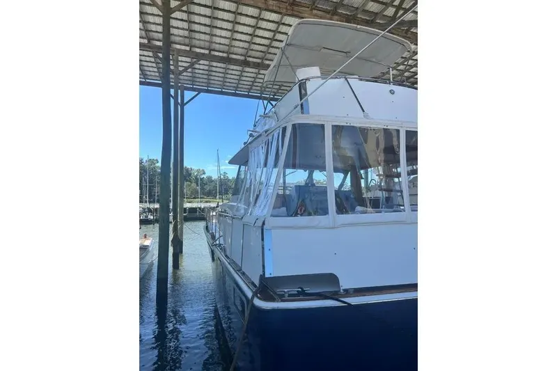 Slide: The Image of 1978 Chris-Craft 45 Commander yacht docked under a covered marina. - 17