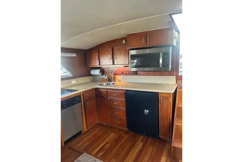 Slide: The Image of 1978 Chris-Craft 45 Commander yacht kitchen with wood cabinets, microwave, and compact appliances. - 19