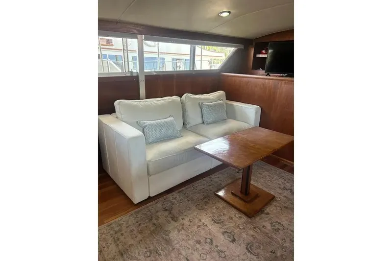 Slide: The Image of Interior of 1978 Chris-Craft 45 Commander with white sofa, wooden table, and TV. - 21