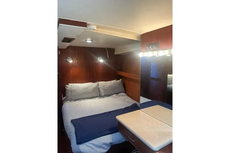 Slide: The Image of Cozy bedroom interior of 1978 Chris-Craft 45 Commander yacht with wood paneling and soft lighting. - 26