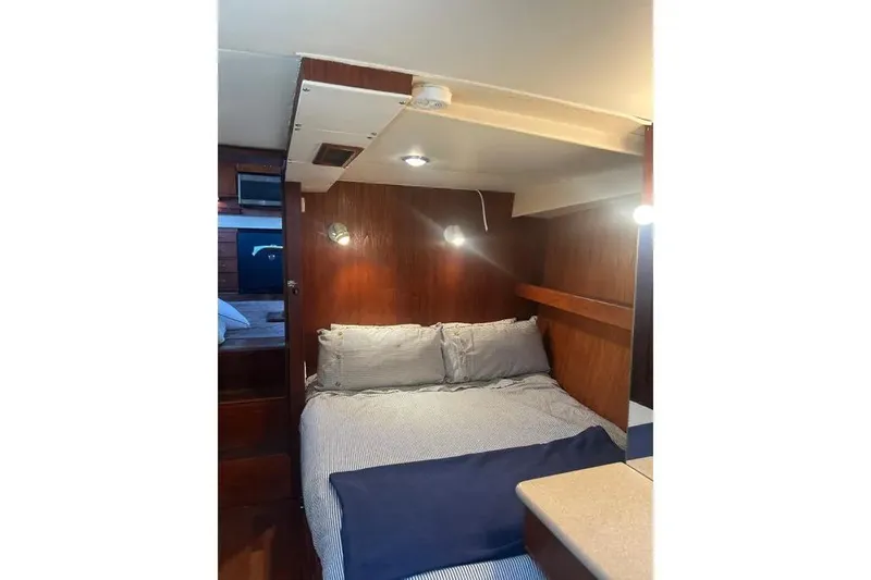 Slide: The Image of 1978 Chris-Craft 45 Commander cabin interior with cozy bed and wooden paneling. - 27