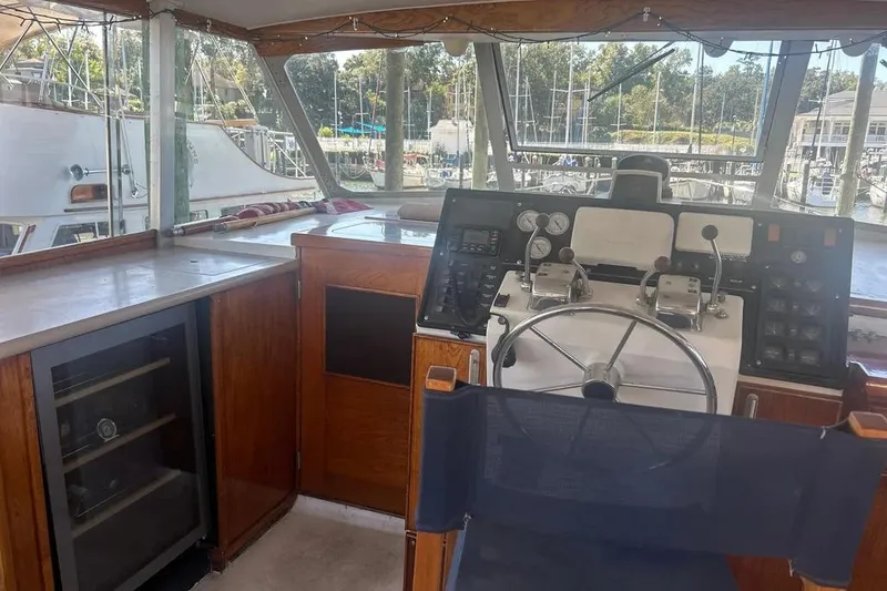 Slide: The Image of 1978 Chris-Craft 45 Commander helm with steering wheel, controls, and marina view. - 43