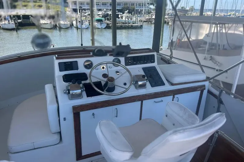 Slide: The Image of 1978 Chris-Craft 45 Commander helm with marina view, featuring classic controls and seating. - 9