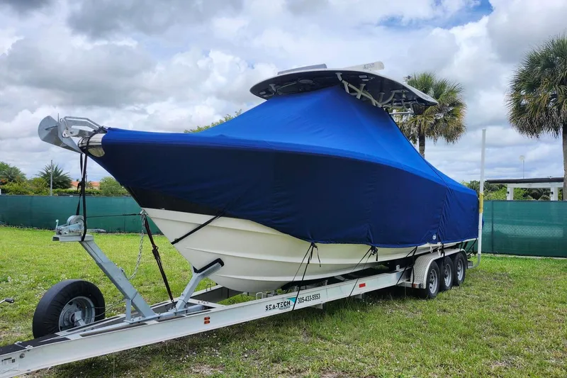 The Image of 2015 Robalo R300 Center Console boat covered on trailer, parked outdoors. - 0