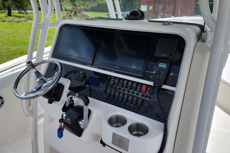 Slide: The Image of 2015 Robalo R300 Center Console dashboard with steering wheel, dual screens, and control panel. - 21