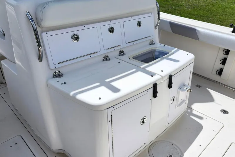 Slide: The Image of 2015 Robalo R300 Center Console boat interior with storage compartments and seating. - 7