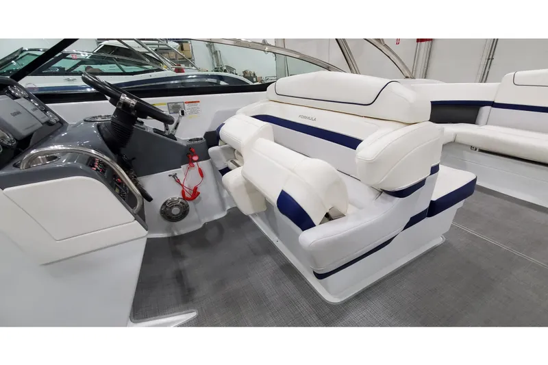 Slide: The Image of 2013 Formula 310 Bowrider interior with white and blue seating, sleek dashboard, and steering wheel. - 17