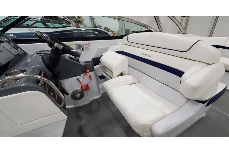 Slide: The Image of 2013 Formula 310 Bowrider interior with sleek dashboard and comfortable white seating. - 18