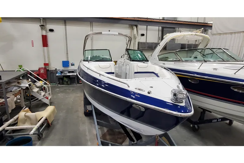 Slide: The Image of 2013 Formula 310 Bowrider boat in indoor storage, showcasing sleek design and blue accents. - 2