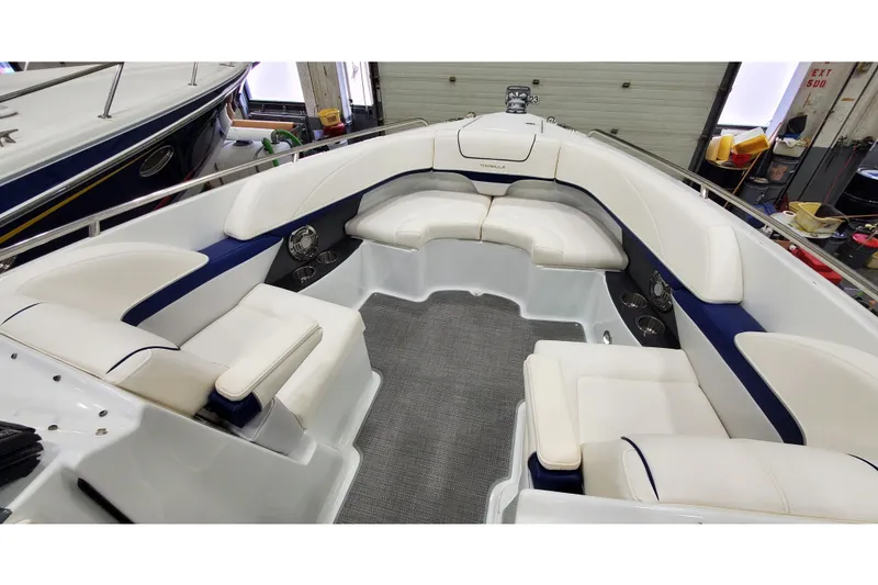 Slide: The Image of 2013 Formula 310 Bowrider interior with white seating and blue accents in a garage setting. - 27