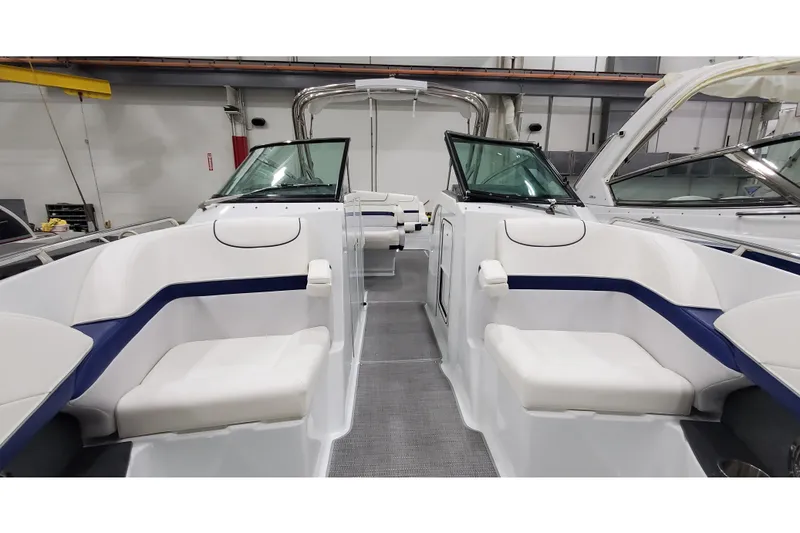 Slide: The Image of 2013 Formula 310 Bowrider interior with white seating and blue accents in a showroom. - 28