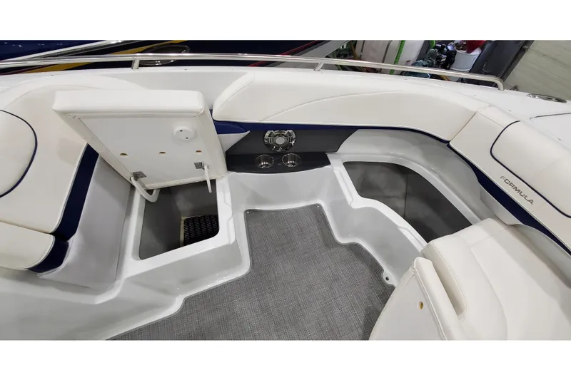 Slide: The Image of Interior view of a 2013 Formula 310 Bowrider boat with white seating and storage compartments. - 29