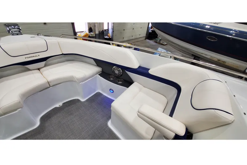 Slide: The Image of 2013 Formula 310 Bowrider interior with white seating and blue accents in a garage setting. - 42