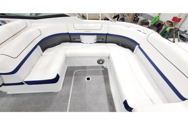Slide: The Image of 2013 Formula 310 Bowrider interior with white and blue seating, spacious layout. - 7