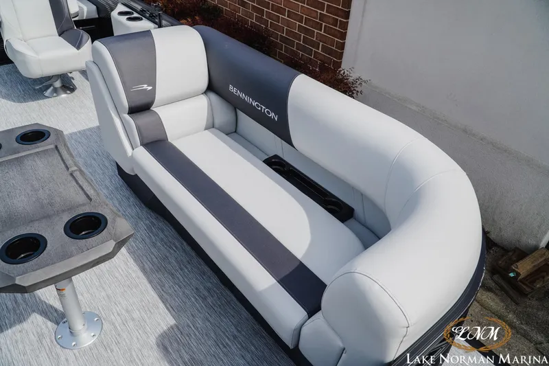 Slide: The Image of 2026 Bennington 22SSB boat interior with plush seating and cup holders at Lake Norman Marina. - 14