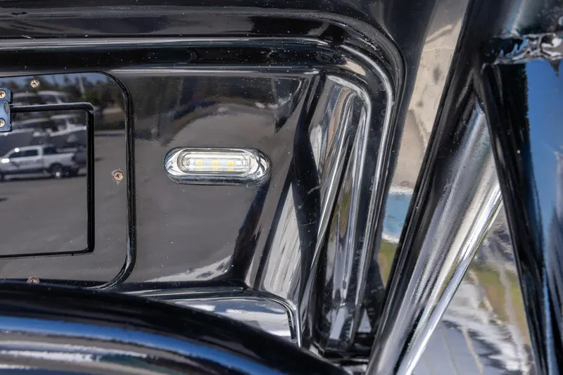 Slide: The Image of Close-up of a 2019 Wellcraft 262 Fisherman boat's sleek black exterior with LED light. - 12