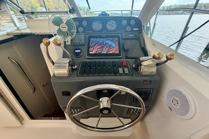 Slide: The Image of Helm of 2000 Tiara Yachts 2900 Coronet with steering wheel and navigation controls. - 15