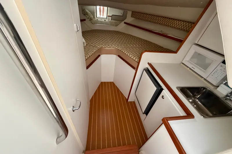 Slide: The Image of 2000 Tiara Yachts 2900 Coronet cabin interior with kitchenette and sleeping area. - 42