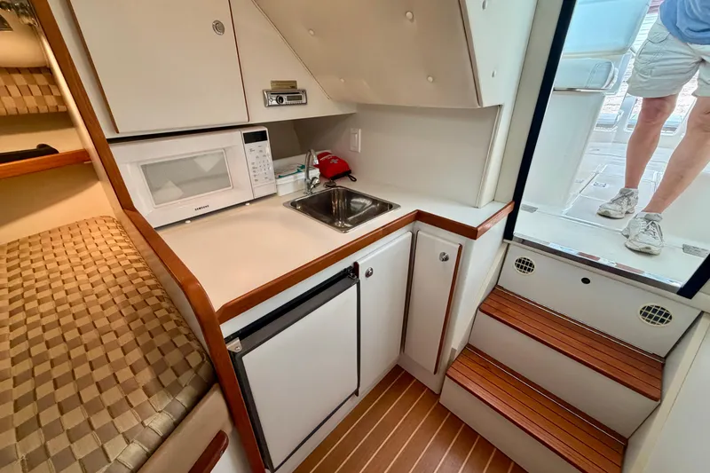 Slide: The Image of Compact kitchen area in a 2000 Tiara Yachts 2900 Coronet, featuring a microwave and sink. - 44