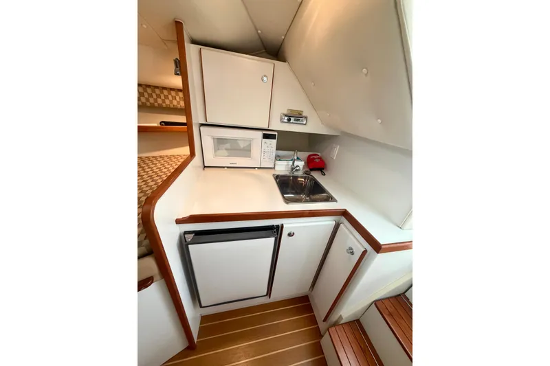 Slide: The Image of 2000 Tiara Yachts 2900 Coronet galley with microwave, sink, and compact refrigerator. - 45