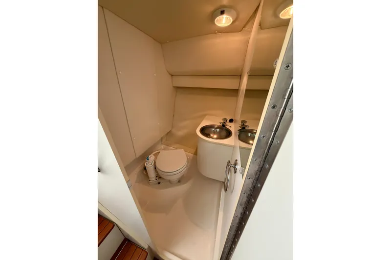 Slide: The Image of Interior of 2000 Tiara Yachts 2900 Coronet, featuring cabin with bed, kitchenette, and wood flooring. - 49