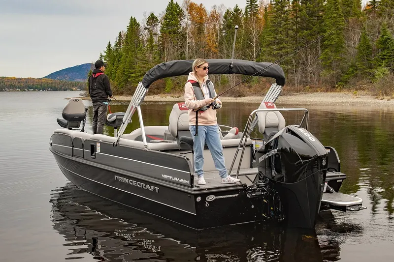 Slide: The Image of Manufacturer Provided Image: 2025 Princecraft Ventura 224 boat on a serene lake with two people fishing. - 16