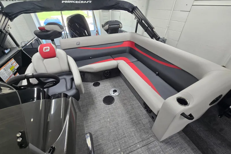 Slide: The Image of 2026 Princecraft Ventura 224 boat interior with gray and red seating, steering wheel, and cup holders. - 6