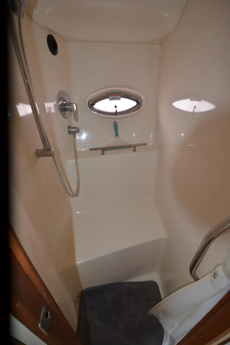 Slide: The Image of Interior of 2007 Sea Ray 38 Sundancer with nautical-themed pillows on a white sofa. - 25