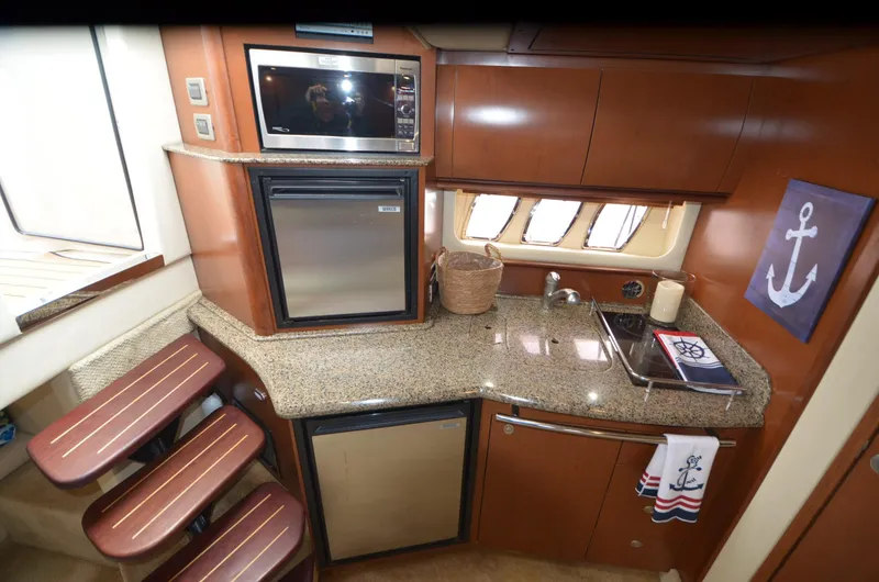 Slide: The Image of Interior of 2007 Sea Ray 38 Sundancer with beige seating and nautical-themed decor. - 28