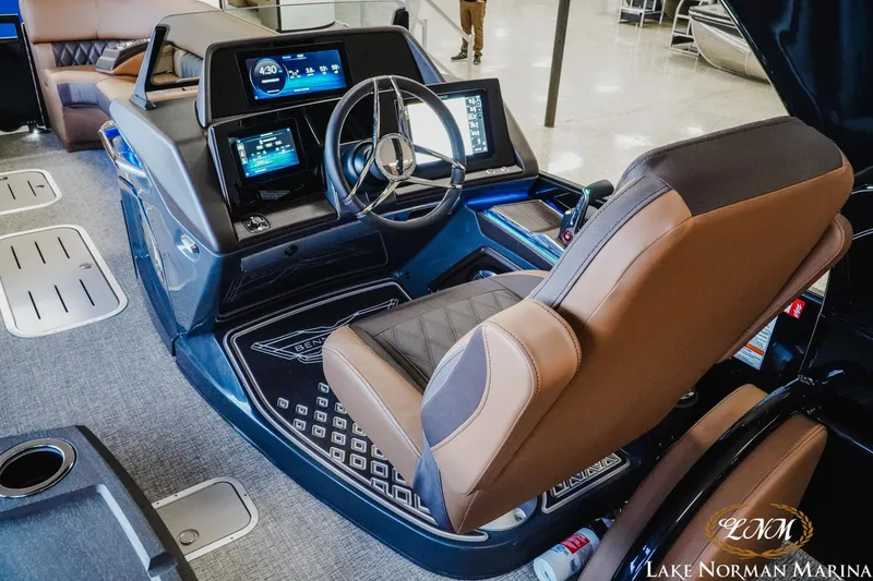 Slide: The Image of 2026 Bennington 25QSBA boat interior with modern dashboard and luxurious captain's chair. - 12