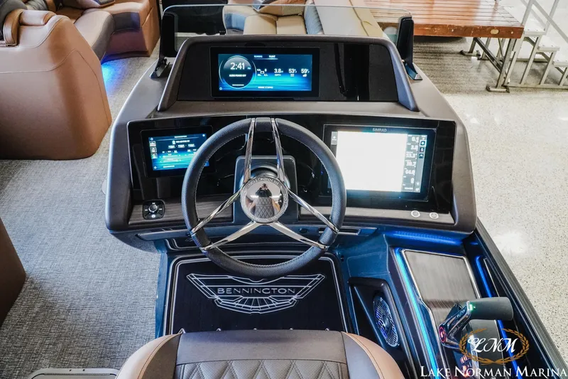 Slide: The Image of 2026 Bennington 25QSBA boat dashboard with advanced digital displays and steering wheel. - 13