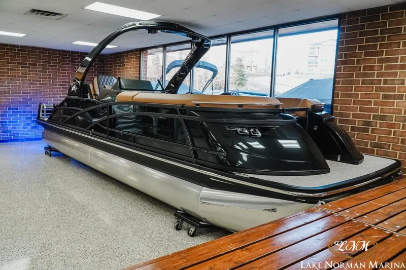 Slide: The Image of 2026 Bennington 25QSBA pontoon boat displayed indoors at Lake Norman Marina. - 3